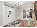 Bright foyer with hardwood floors, chandelier, and arched doorway with decorative wreath at 7653 Carriage House Way, Zionsville, IN 46077
