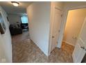 Bright entryway leading to the living room and bathroom featuring modern flooring and neutral walls at 8409 Bolero Way, Camby, IN 46113