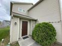 A close-up of the front door, framed by lush greenery, welcomes you home at 8409 Bolero Way, Camby, IN 46113