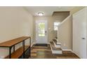 Bright foyer with modern flooring, a staircase, and a view of the front door, creating an open and welcoming entry at 9307 W Dockside Cir, Pendleton, IN 46064