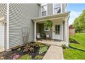 Inviting front porch with seating and decorative plants, framed by lush landscaping, and a welcoming entrance at 9307 W Dockside Cir, Pendleton, IN 46064