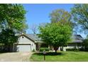 Charming single-story home featuring an attached garage, inviting curb appeal, and mature trees at 931 Beech Dr, Greenwood, IN 46142