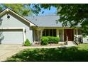 Inviting home exterior featuring an attached garage, manicured landscaping, and a welcoming front entrance at 931 Beech Dr, Greenwood, IN 46142