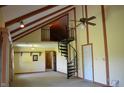 Spacious living room showcasing a unique spiral staircase, vaulted ceilings, and ample natural light at 931 Beech Dr, Greenwood, IN 46142