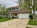 Classic home with a two-car garage, front porch, green siding, and a spacious, well-kept lawn at 1018 Redwood Dr, Lebanon, IN 46052