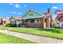 Brick home with a covered porch and well-manicured lawn under a clear blue sky at 1029 E Yoke St, Indianapolis, IN 46203