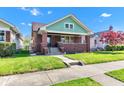 Inviting brick home with a cozy front porch and lush green lawn at 1029 E Yoke St, Indianapolis, IN 46203