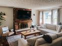 Inviting living room featuring a brick fireplace, comfortable seating, and natural light, perfect for relaxation and gatherings at 106 Walnut St, Southport, IN 46227