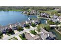 Aerial view of waterfront homes on a lake with mature trees and well-manicured lawns at 11484 Lake Stonebridge Ln, Fishers, IN 46037
