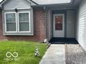 Welcoming front entrance featuring brick accents and a well-manicured lawn at 11748 E 10Th St, Indianapolis, IN 46229