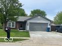 Charming single-story home with well-maintained lawn and attached two car garage at 11748 E 10Th St, Indianapolis, IN 46229