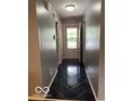 Inviting hallway with glossy tile flooring and neutral paint at 11748 E 10Th St, Indianapolis, IN 46229