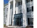 Exterior angle of the Fordham House entrance, featuring white architectural pillars and a blue entrance door at 12873 Tradd St # 2B, Carmel, IN 46032
