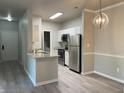 Bright kitchen featuring stainless steel appliances, white cabinets, and modern light fixtures at 12873 Tradd St # 2B, Carmel, IN 46032
