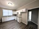 Bright kitchen features white cabinetry, a large window, and wood-look vinyl flooring at 1303 9Th St, Columbus, IN 47201