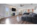 Spacious living room with hardwood floors, a cozy fireplace, large windows, and comfortable seating, great for entertaining at 15332 Atkinson Dr, Noblesville, IN 46060