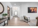 Inviting foyer boasts stylish decor, neutral paint, an artistic highland cow print and hardwood floors at 15882 Vitalize Run, Fishers, IN 46040