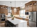 Gorgeous kitchen with stainless appliances, custom wood cabinets, large island and designer pendant lights at 15882 Vitalize Run, Fishers, IN 46040