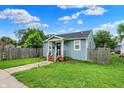 Lovely light blue house featuring a beautiful green lawn, sidewalk and a wooden fence at 1641 Iowa St, Indianapolis, IN 46203