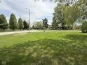 Spacious front yard featuring a lush green lawn and mature trees in a quiet neighborhood at 2350 Brewer Dr, Indianapolis, IN 46227