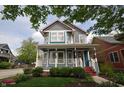 Beautiful two-story house with a welcoming front porch, nice landscaping, and colorful siding at 2363 N Pennsylvania St, Indianapolis, IN 46205
