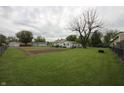 Large grassy backyard with mature trees and a view of neighboring houses at 2657 Mars Hill St, Indianapolis, IN 46241