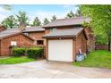 This two-story home features a detached one-car garage with a white door at 3165 Sycamore Dr, Columbus, IN 47203
