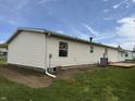 Side view of the home showing vinyl siding and well-maintained exterior with a small deck at 3209 Pebblebrook Dr, Elwood, IN 46036
