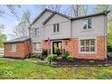 Beautiful brick home with lush landscaping, featuring an American flag, decorative wreaths, and manicured lawn at 3444 Briar Pl, Carmel, IN 46033