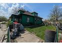 An exterior shot shows the side and backyard of a home with overgrown landscaping at 3602 E 22Nd St, Indianapolis, IN 46218