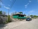 Side view of a weathered home with a narrow driveway, featuring a parked car at 3602 E 22Nd St, Indianapolis, IN 46218