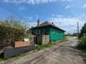 Backyard view shows the exterior of a home and alley with a debris pile at 3602 E 22Nd St, Indianapolis, IN 46218