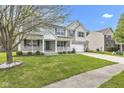 Two-story home boasts a brick and vinyl facade, attached two-car garage, well-kept lawn, and charming front porch at 3652 Newberry Rd, Plainfield, IN 46168