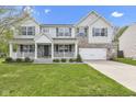 Two-story home boasts a brick and vinyl facade, attached two-car garage, well-kept lawn, and charming front porch at 3652 Newberry Rd, Plainfield, IN 46168