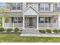 Inviting front porch features white columns, brick accents, and green shutters for a classic curb appeal at 3652 Newberry Rd, Plainfield, IN 46168