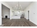 Open-concept layout with modern chandelier and updated stainless steel appliances in the kitchen at 3845 Cornelius Ave, Indianapolis, IN 46208