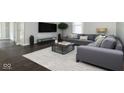 Cozy living room with grey L-shaped sofa, modern decor, hardwood floors, and ample natural light at 400 N Sycamore St, Martinsville, IN 46151