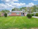 Inviting brick ranch-style house with green lawn, mature trees, and a serene neighborhood setting at 4029 N Euclid Ave, Indianapolis, IN 46226