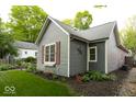 Side view of home with gray siding, red shutters, manicured lawn and pretty landscaping at 440 Linden St, Zionsville, IN 46077