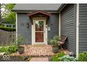 Close-up of the front door showcasing the brick pathway, welcome mat, and potted rose bushes at 440 Linden St, Zionsville, IN 46077