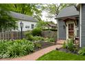 View of the front yard featuring a brick pathway, lush landscaping, and well-maintained lawn at 440 Linden St, Zionsville, IN 46077