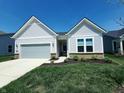 Inviting single-story home with a gray garage door, manicured lawn, and attractive landscaping at 4734 Cleome Dr, Plainfield, IN 46168