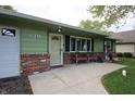 Close up shot of the brick-lined front porch with chairs at this ranch-style home at 5041 Norcroft Dr, Indianapolis, IN 46221