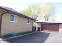 Exterior view showing the tan brick, the detached garage, and a black driveway at 518 Cherry St, Beech Grove, IN 46107