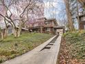 Two-story brick home with a concrete driveway and steps through the landscaped front yard at 5181 E Pleasant Run Pkwy S Dr, Indianapolis, IN 46219