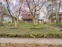 Two-story brick home with a lush front yard featuring rocks and trees at 5181 E Pleasant Run Pkwy S Dr, Indianapolis, IN 46219