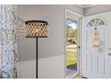 Bright entryway with white door and wall paneling, featuring stylish lamp and decor at 57 Hadley St, Mooresville, IN 46158