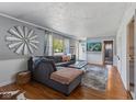 Inviting living room features gray sectional couch, wood floors, and decorative windmill at 57 Hadley St, Mooresville, IN 46158