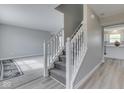 Welcoming foyer with a carpeted staircase, light gray walls and hardwood flooring, leading to the living area at 7202 Red Lake Ct, Indianapolis, IN 46217