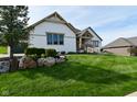 Landscaped front yard with lush green grass, decorative rocks, and flowering bushes at 728 Christin Ct, Plainfield, IN 46168